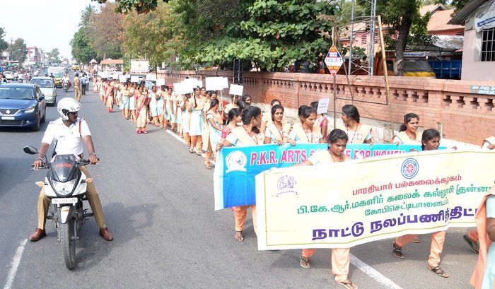 Students of PKR Arts College for Women participating in an environmental awareness rally, holding banners and placards promoting sustainability and social responsibility.