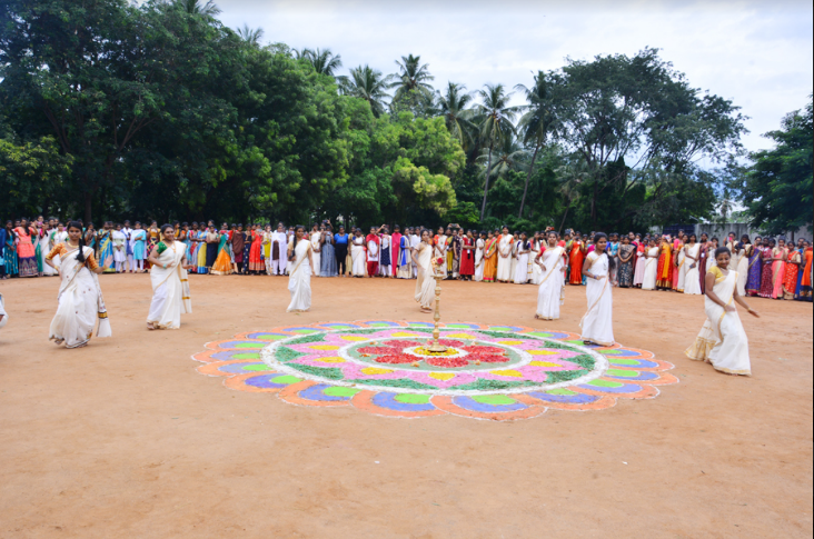 Students dressed in traditional Kerala attire perform a group Thiruvathira dance during the Onam celebration at PKR Arts College for Women, surrounded by an enthusiastic audience in the college courtyard.