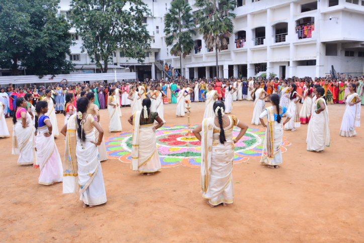 Students dressed in traditional Kerala attire perform a group Thiruvathira dance during the Onam celebration at PKR Arts College for Women, surrounded by an enthusiastic audience in the college courtyard.